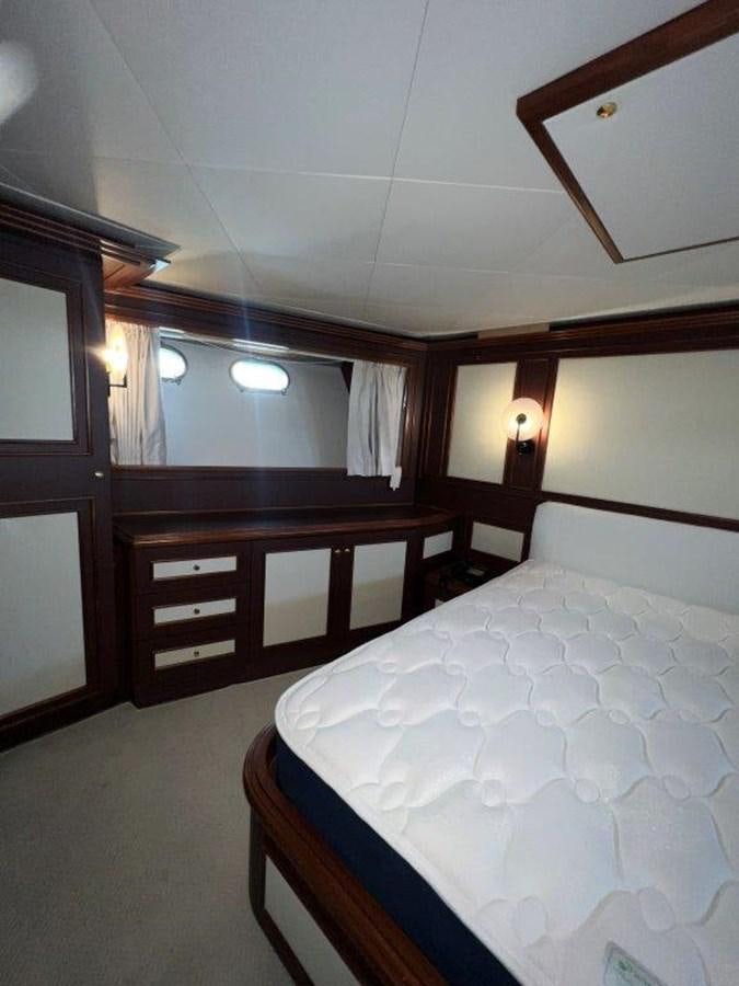 a bedroom with a bed and a mirror aboard MYEERAH Yacht for Sale