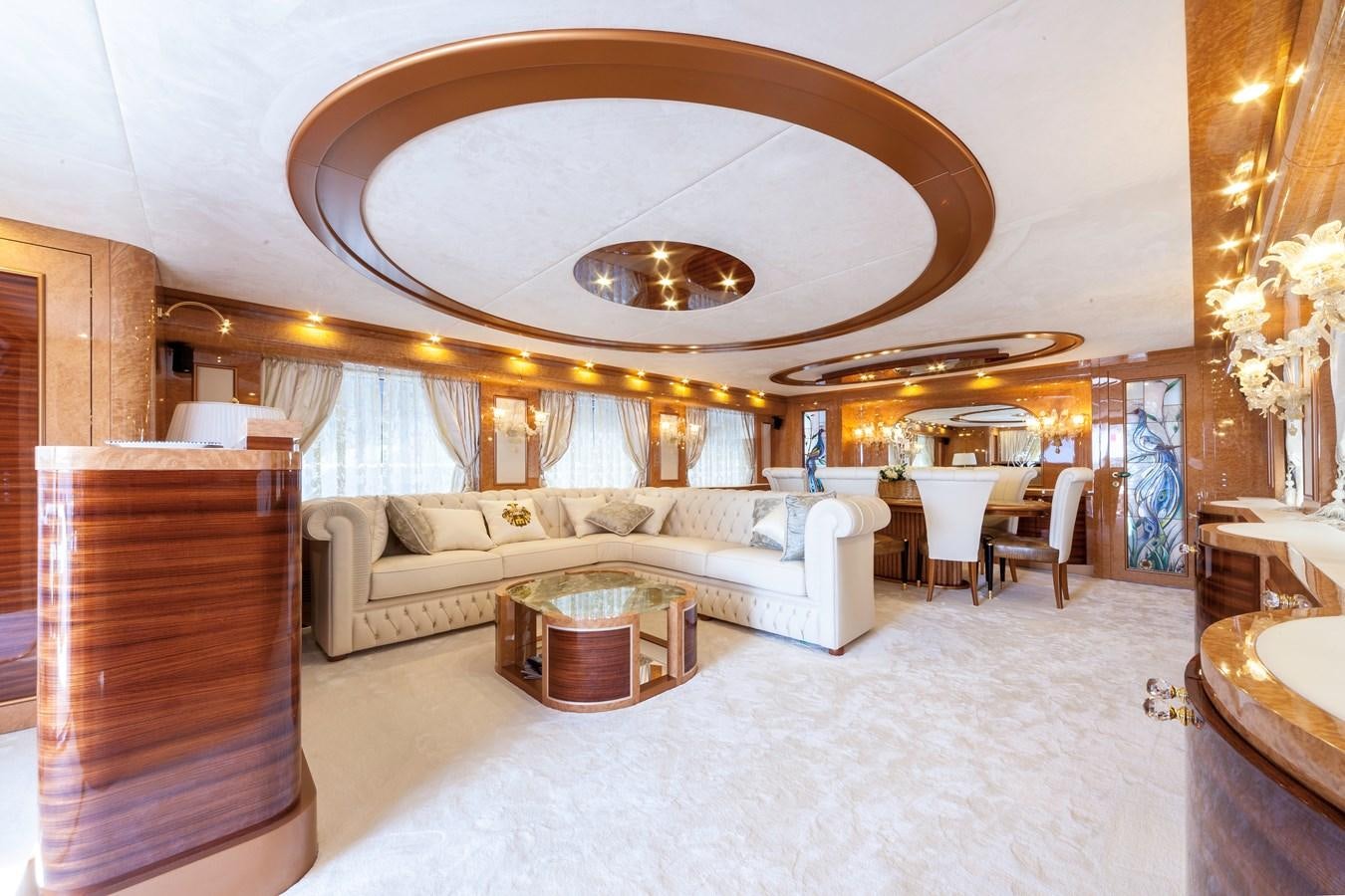 a large living room with a large white couch and a large chandelier aboard DUCHESSA Yacht for Sale