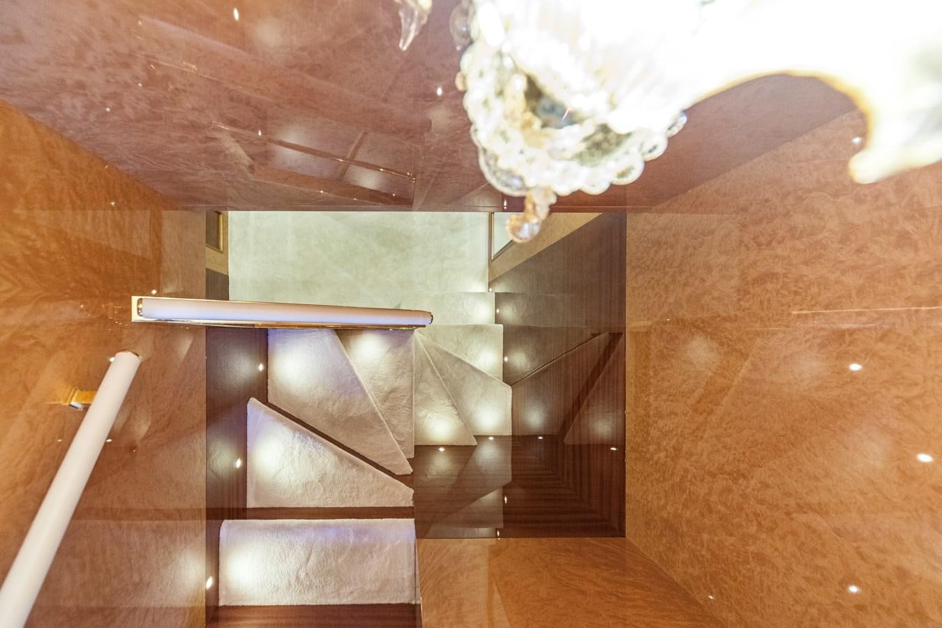 a room with a staircase and a chandelier aboard DUCHESSA Yacht for Sale