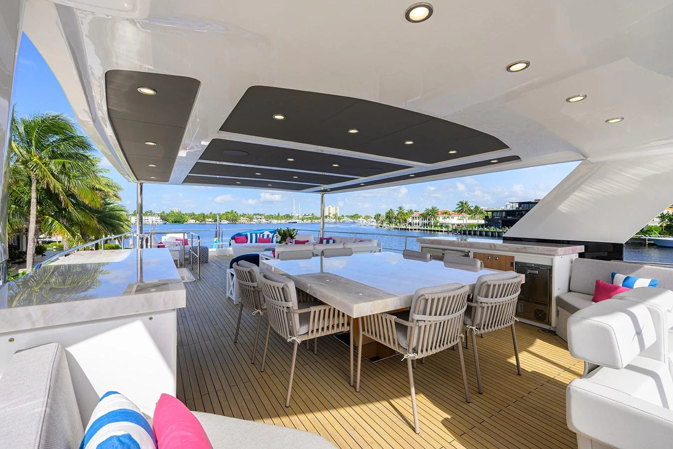 a large lounge area with a pool and a large patio with a large building and trees aboard C3 Yacht for Sale