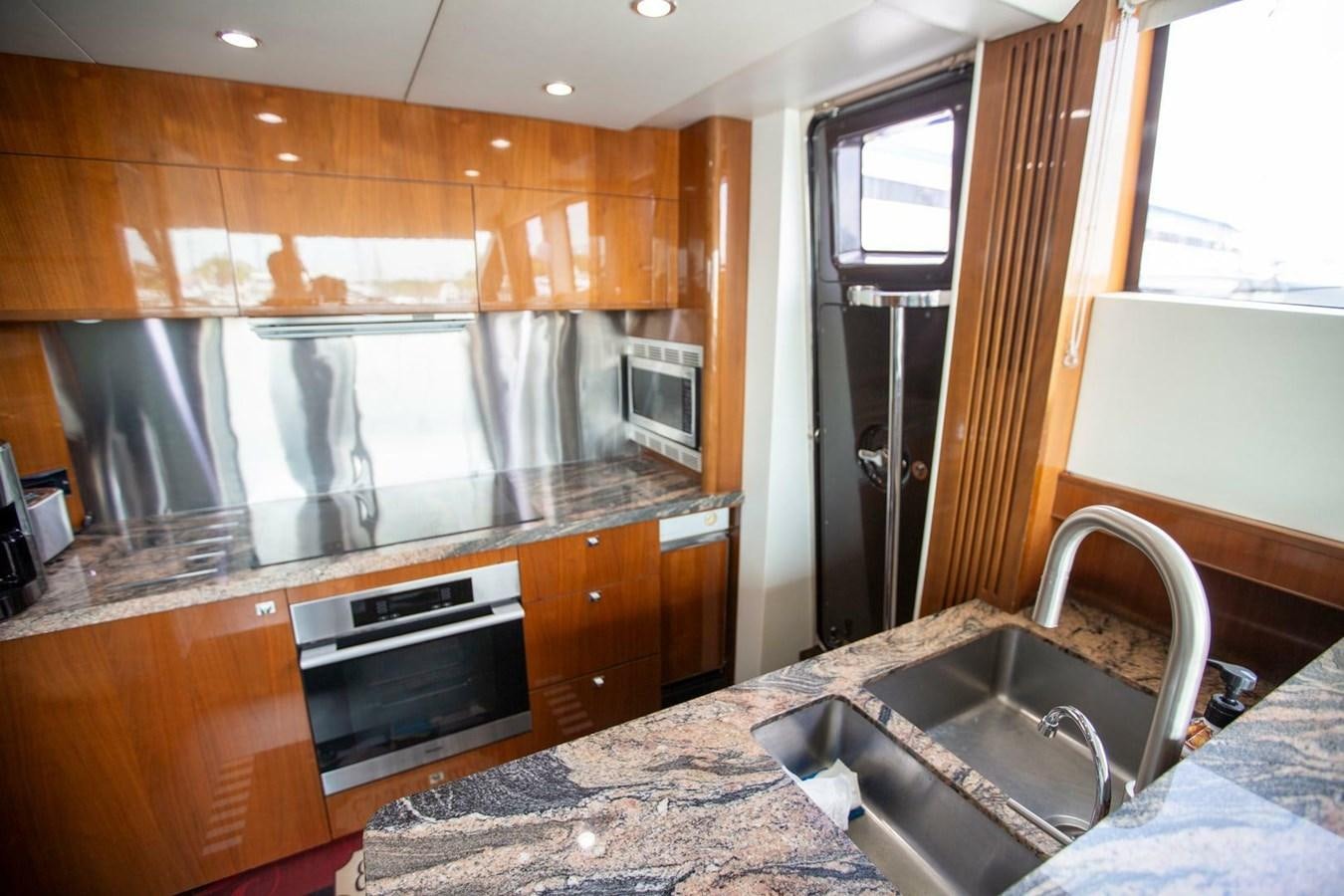 a kitchen with wooden cabinets aboard ENTOURAGE Yacht for Sale