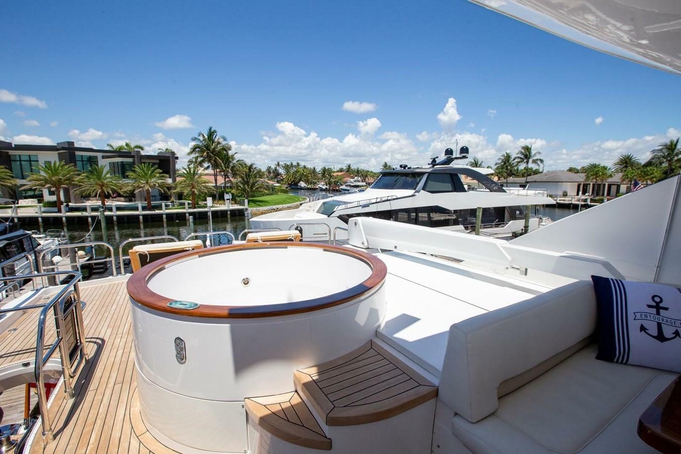 a pool with lounge chairs and umbrellas on a sunny day aboard ENTOURAGE Yacht for Sale
