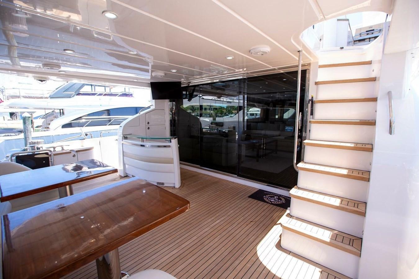 a room with a wood floor and a wood table with a white shelf and a wood bench with aboard ENTOURAGE Yacht for Sale