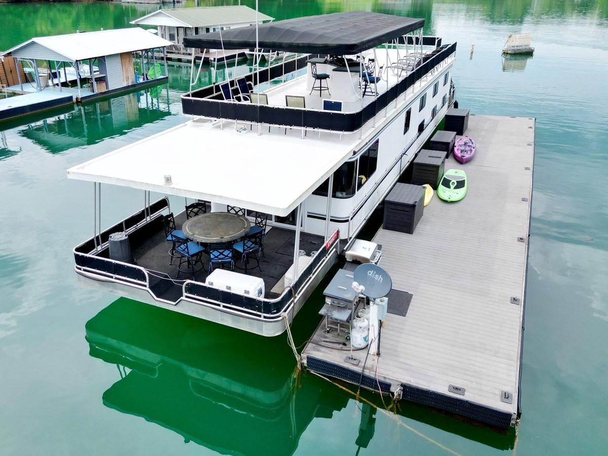 a boat docked at a pier aboard 2012 MAJESTIC 16 X 75WB HOUSEBOAT NLSD Yacht for Sale