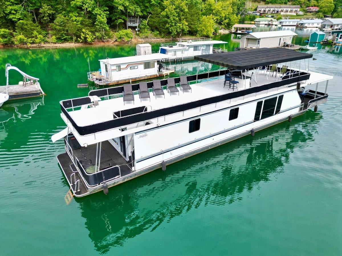a boat docked in a harbor aboard 2012 MAJESTIC 16 X 75WB HOUSEBOAT NLSD Yacht for Sale
