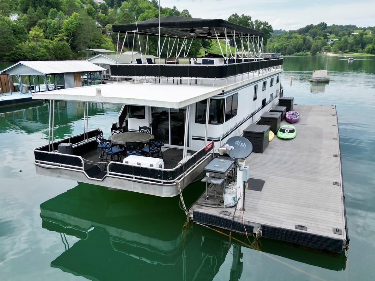 a boat docked at a pier aboard 2012 MAJESTIC 16 X 75WB HOUSEBOAT NLSD Yacht for Sale