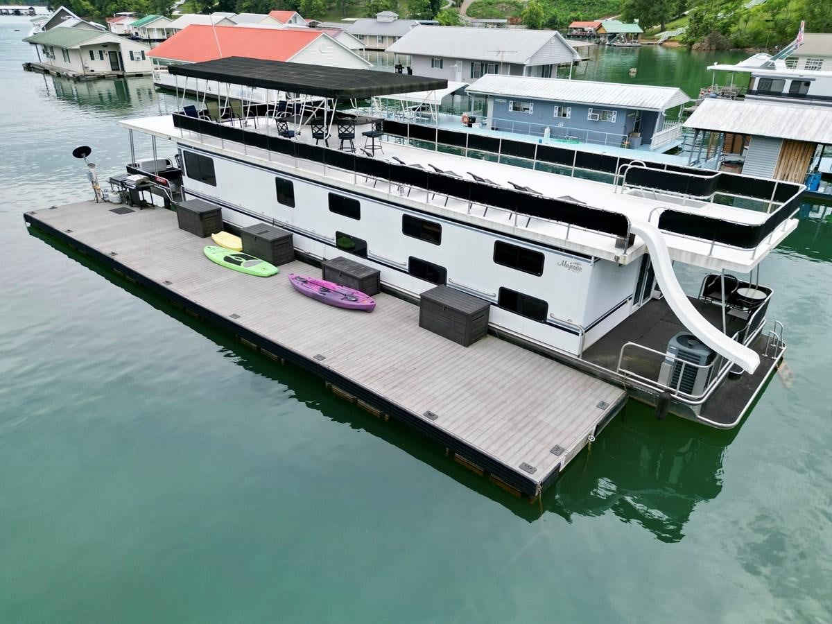 a large boat in the water aboard 2012 MAJESTIC 16 X 75WB HOUSEBOAT NLSD Yacht for Sale