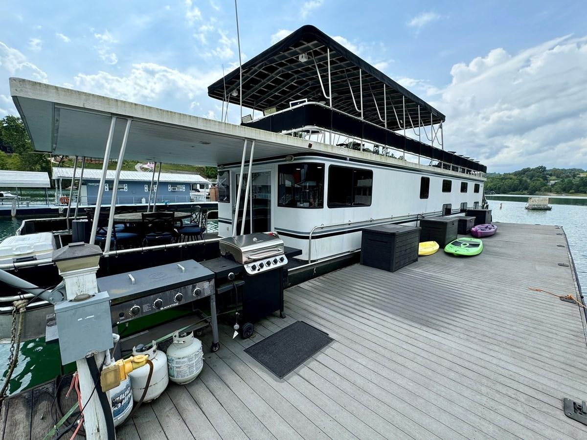 a boat docked at a pier aboard 2012 MAJESTIC 16 X 75WB HOUSEBOAT NLSD Yacht for Sale