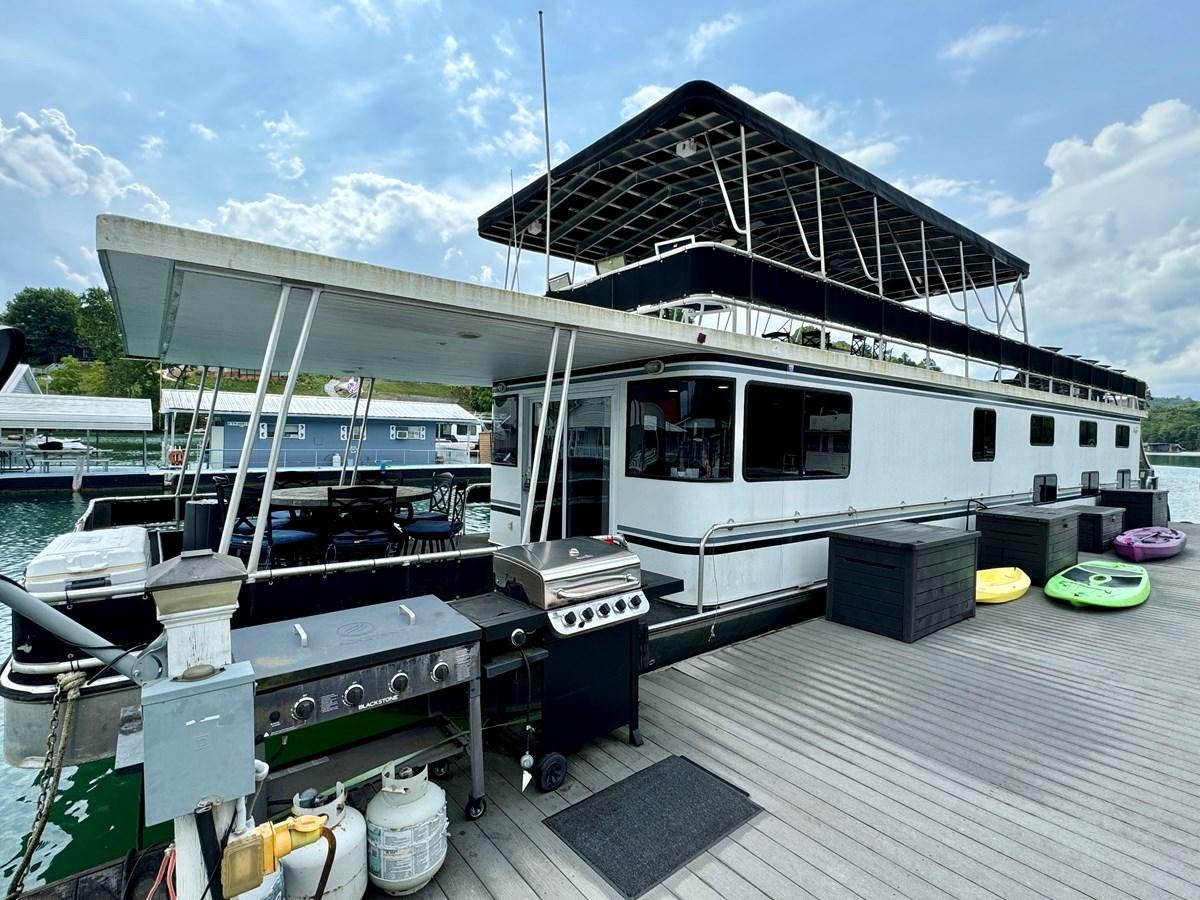 a boat docked at a pier aboard 2012 MAJESTIC 16 X 75WB HOUSEBOAT NLSD Yacht for Sale