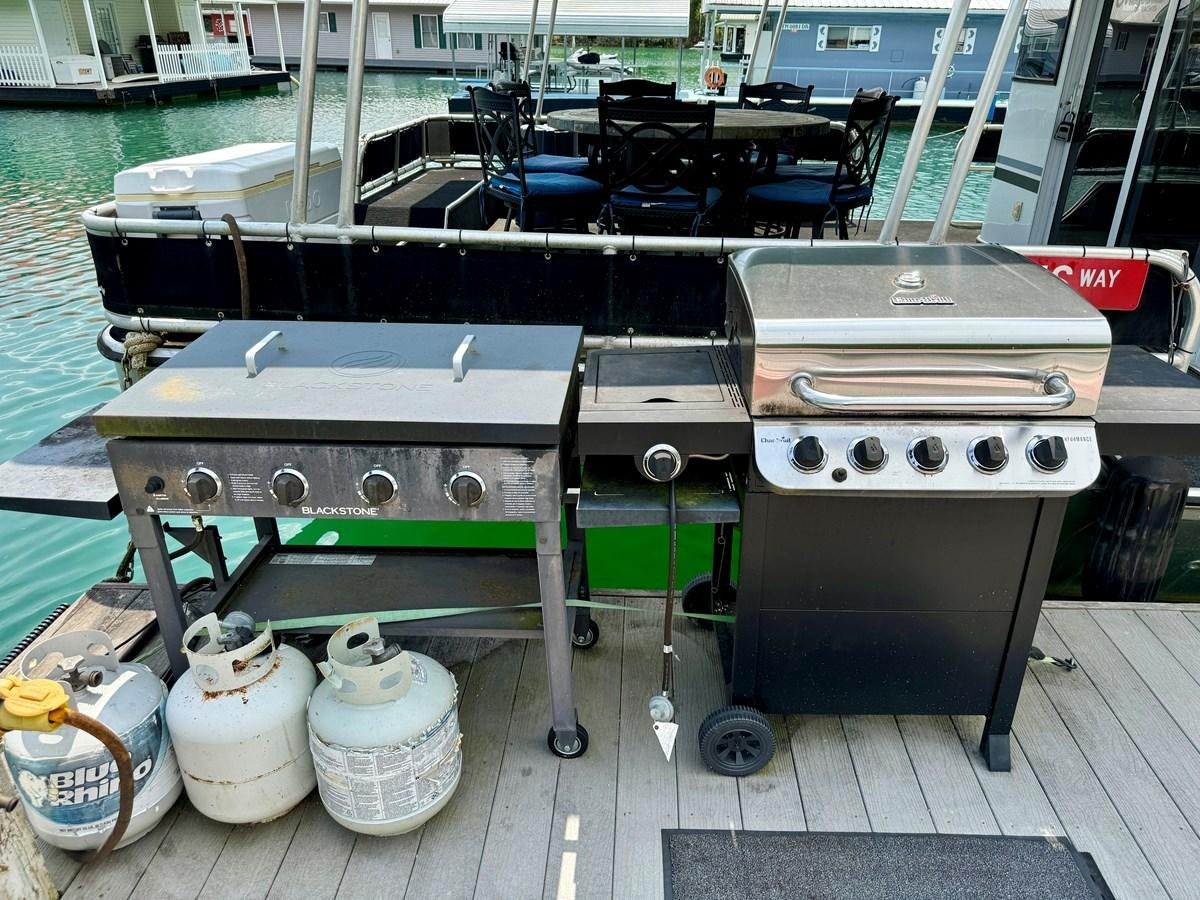 a boat with a table and chairs aboard 2012 MAJESTIC 16 X 75WB HOUSEBOAT NLSD Yacht for Sale