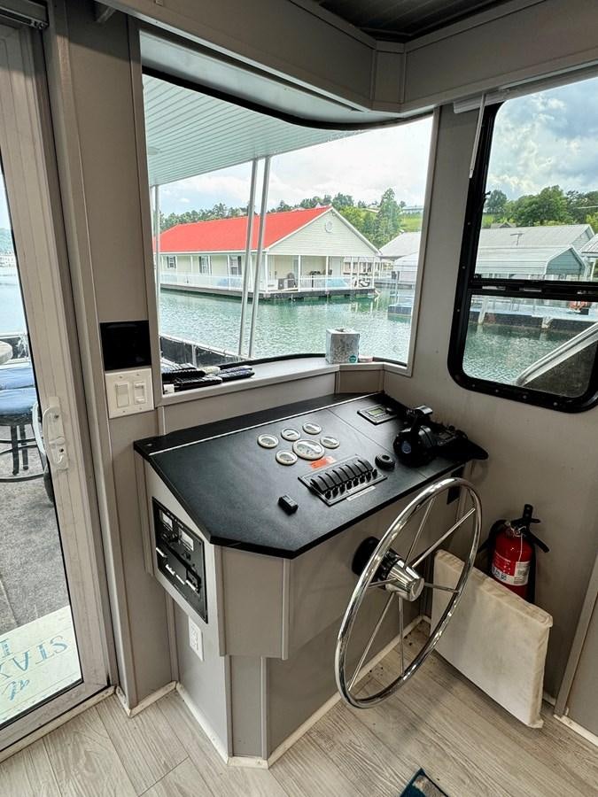 a stove and a window aboard 2012 MAJESTIC 16 X 75WB HOUSEBOAT NLSD Yacht for Sale