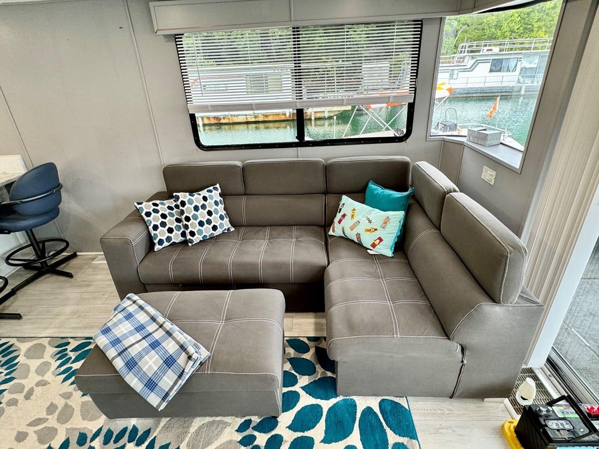 a couch with pillows on it aboard 2012 MAJESTIC 16 X 75WB HOUSEBOAT NLSD Yacht for Sale