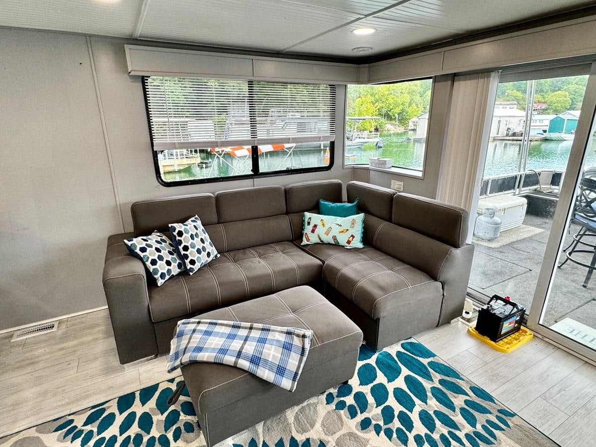 a couch in a living room aboard 2012 MAJESTIC 16 X 75WB HOUSEBOAT NLSD Yacht for Sale