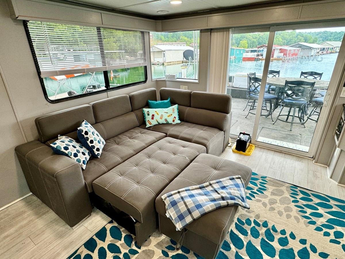 a couch with pillows on it aboard 2012 MAJESTIC 16 X 75WB HOUSEBOAT NLSD Yacht for Sale