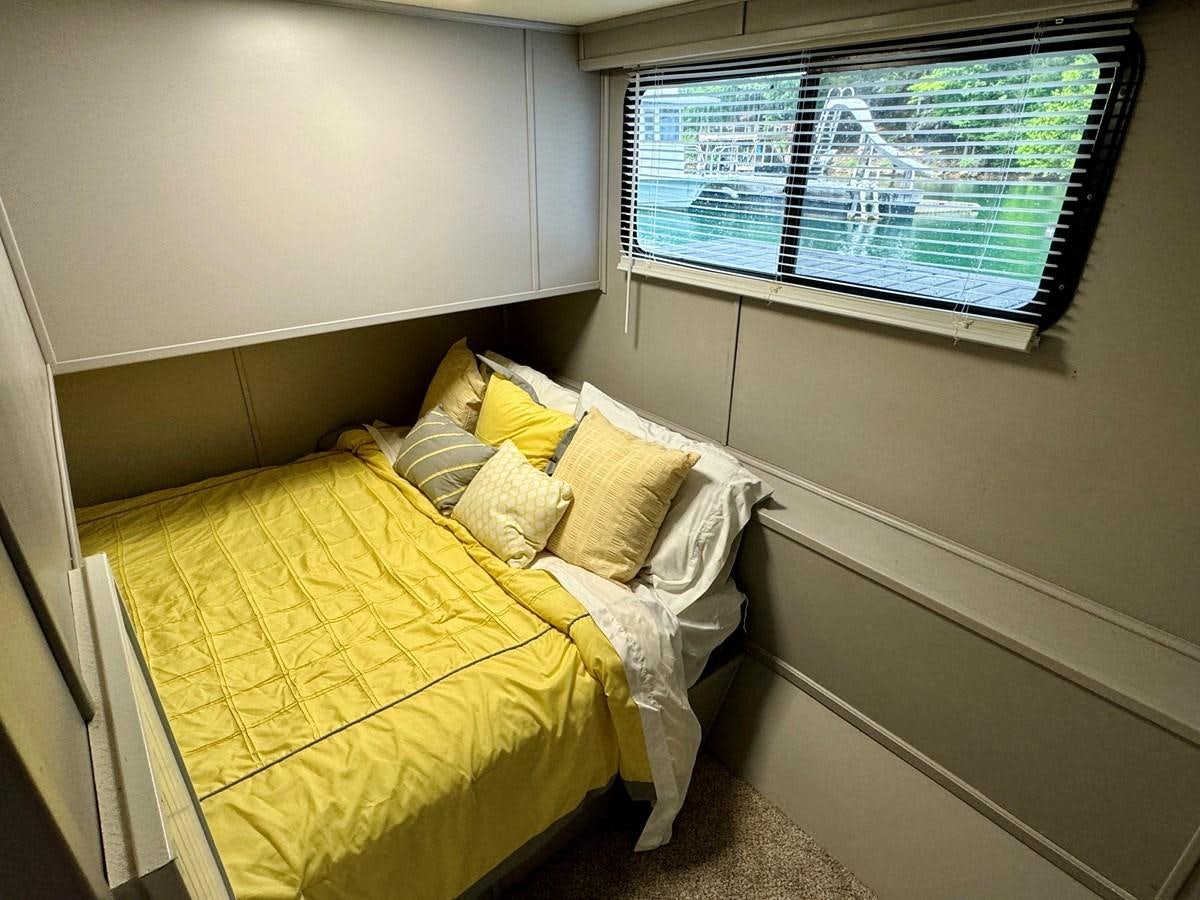 a bed with a yellow sheet aboard 2012 MAJESTIC 16 X 75WB HOUSEBOAT NLSD Yacht for Sale