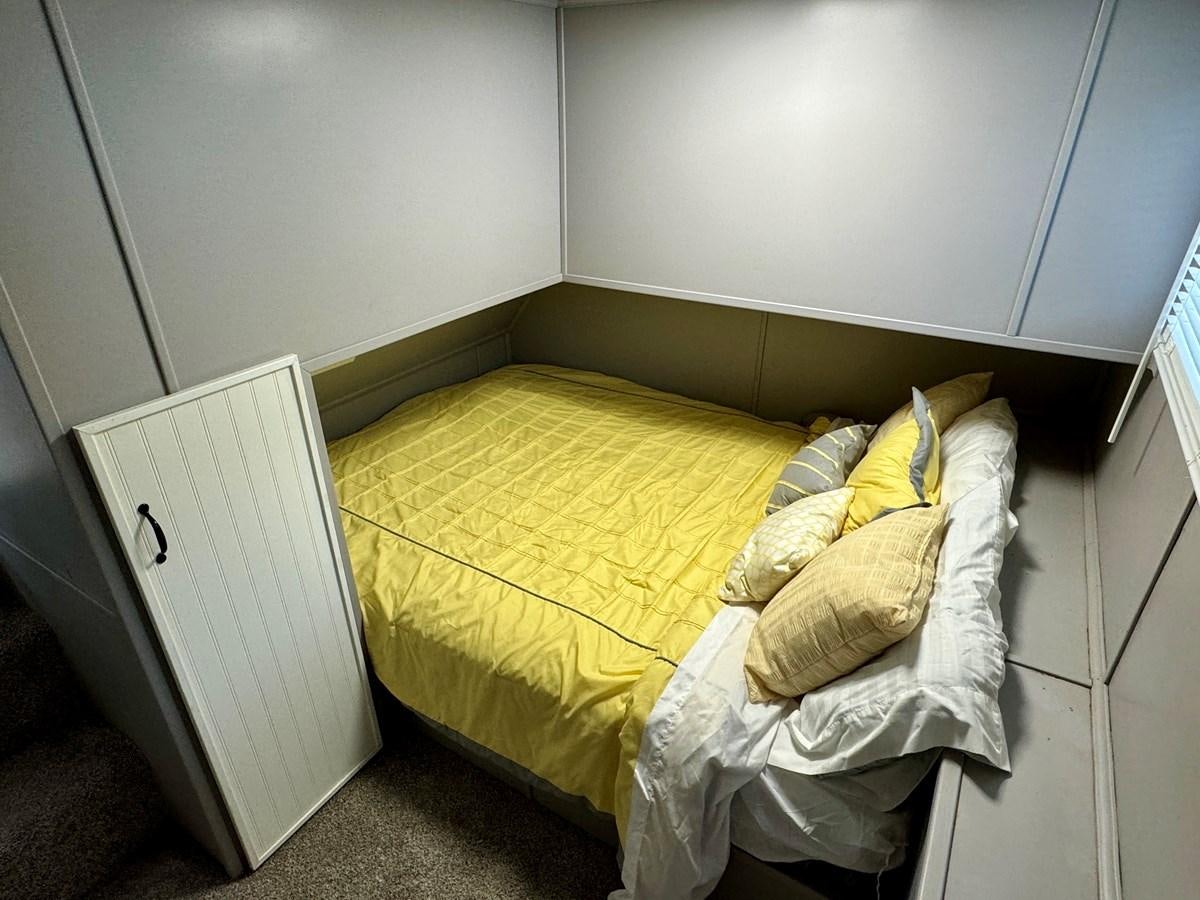 a small bed in a room aboard 2012 MAJESTIC 16 X 75WB HOUSEBOAT NLSD Yacht for Sale