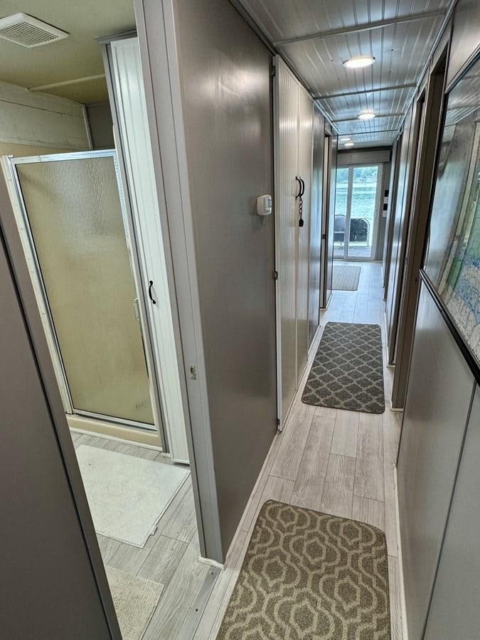 a hallway with doors aboard 2012 MAJESTIC 16 X 75WB HOUSEBOAT NLSD Yacht for Sale