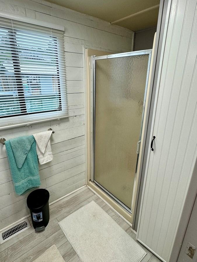 a bathroom with a glass door aboard 2012 MAJESTIC 16 X 75WB HOUSEBOAT NLSD Yacht for Sale