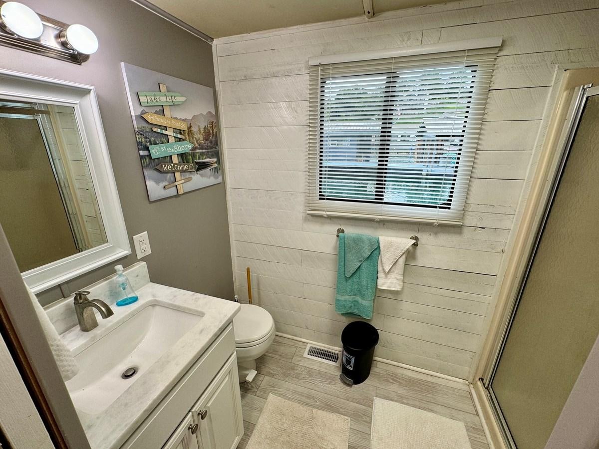 a bathroom with a toilet and sink aboard 2012 MAJESTIC 16 X 75WB HOUSEBOAT NLSD Yacht for Sale