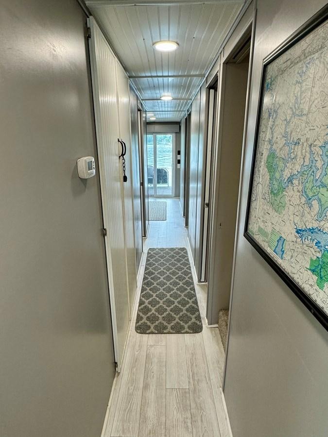 a hallway with a door and a rug on the floor aboard 2012 MAJESTIC 16 X 75WB HOUSEBOAT NLSD Yacht for Sale