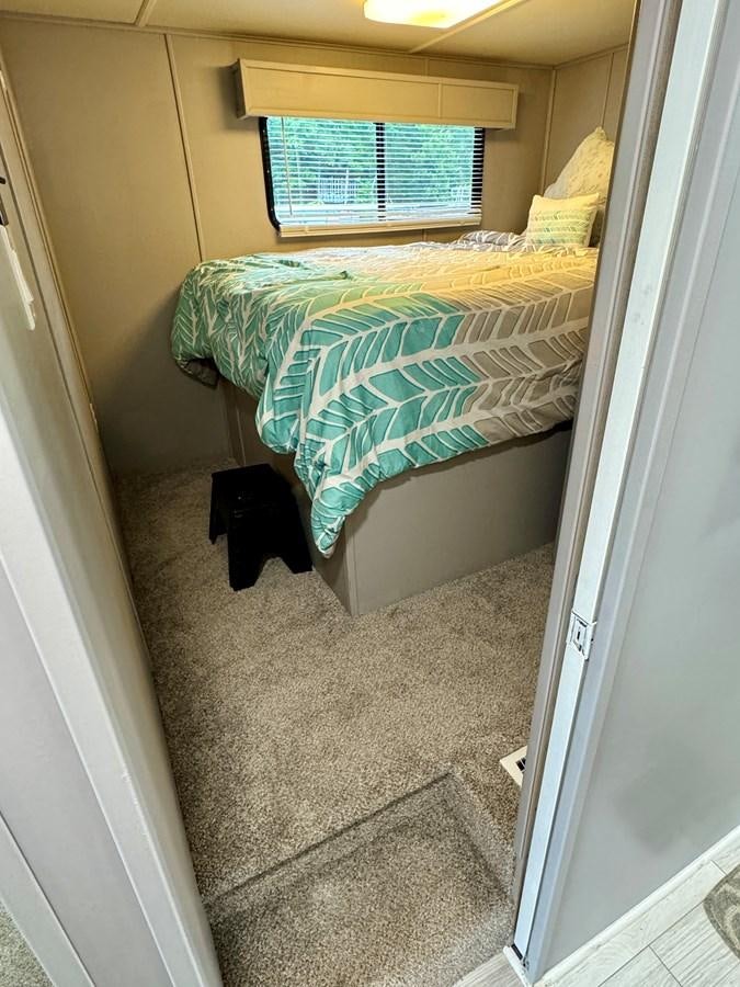 a bed in a room aboard 2012 MAJESTIC 16 X 75WB HOUSEBOAT NLSD Yacht for Sale