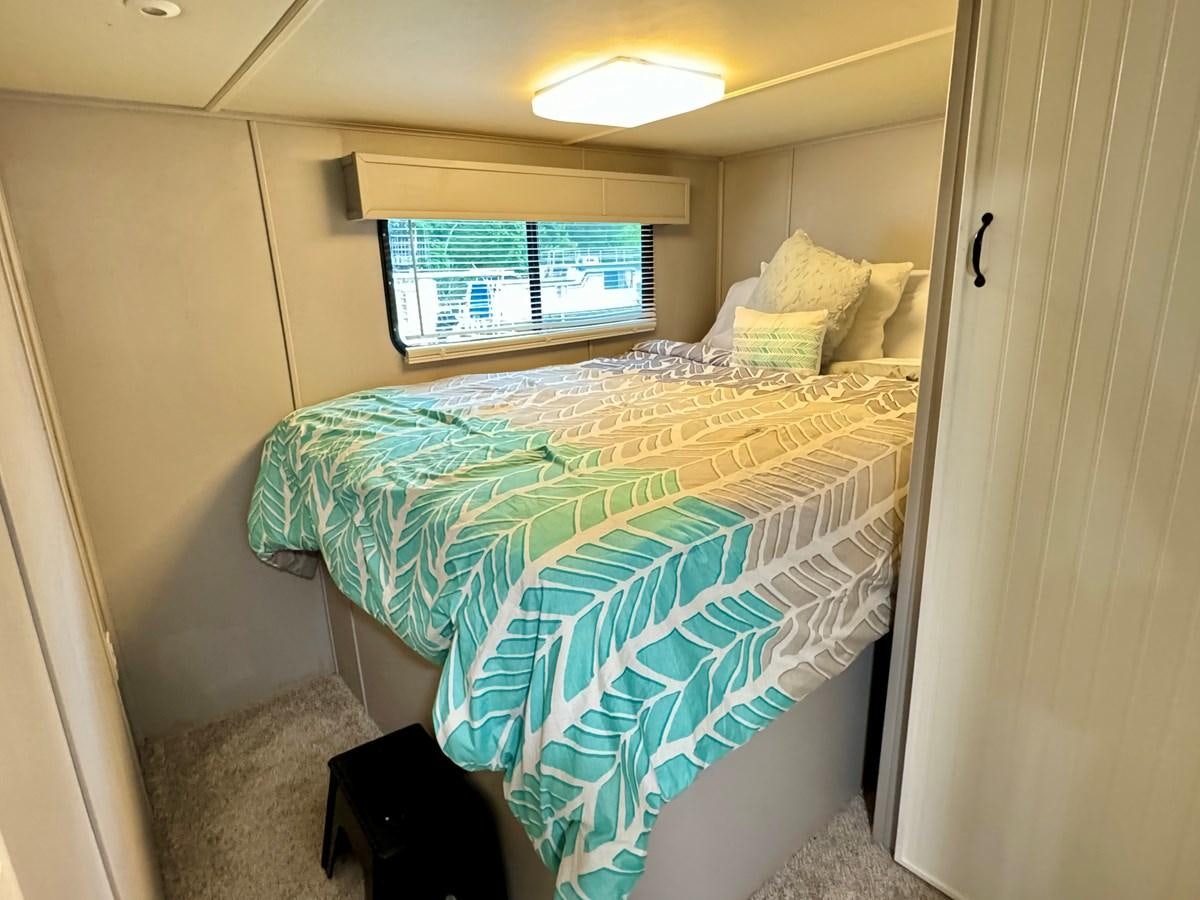 a bed with a blue sheet aboard 2012 MAJESTIC 16 X 75WB HOUSEBOAT NLSD Yacht for Sale