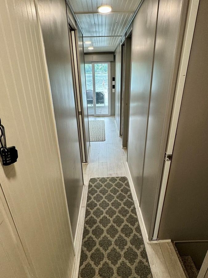 a hallway with glass doors aboard 2012 MAJESTIC 16 X 75WB HOUSEBOAT NLSD Yacht for Sale