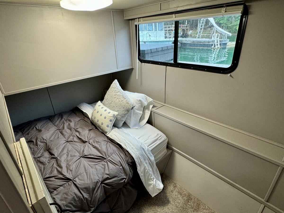 a bed with pillows aboard 2012 MAJESTIC 16 X 75WB HOUSEBOAT NLSD Yacht for Sale