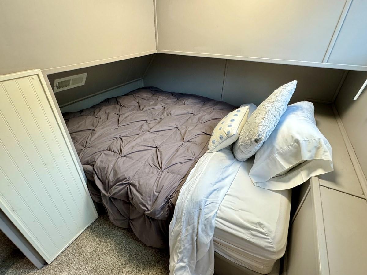 a bed with a blanket on it aboard 2012 MAJESTIC 16 X 75WB HOUSEBOAT NLSD Yacht for Sale