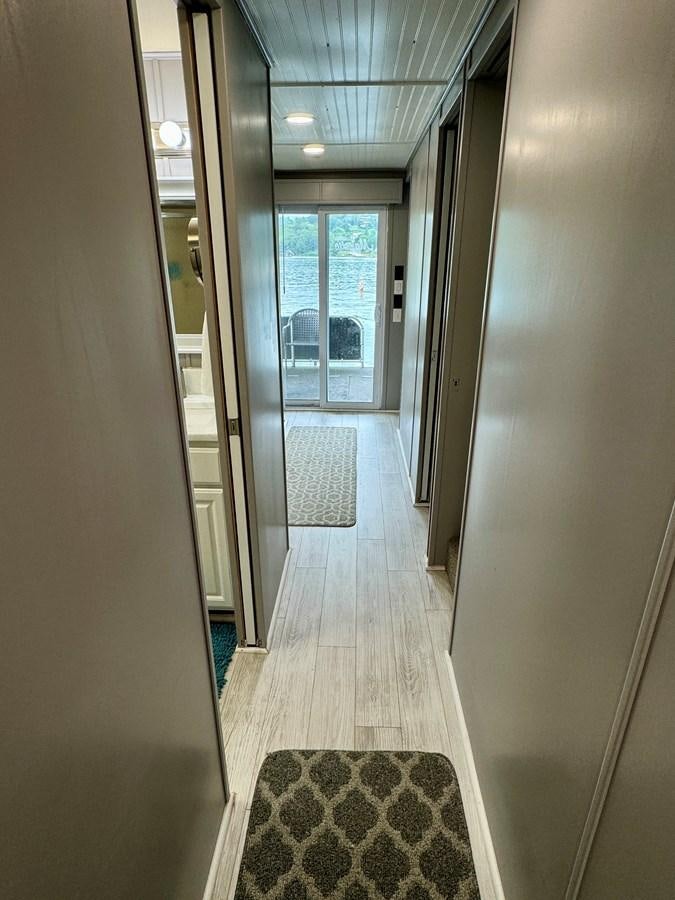 a hallway with doors aboard 2012 MAJESTIC 16 X 75WB HOUSEBOAT NLSD Yacht for Sale