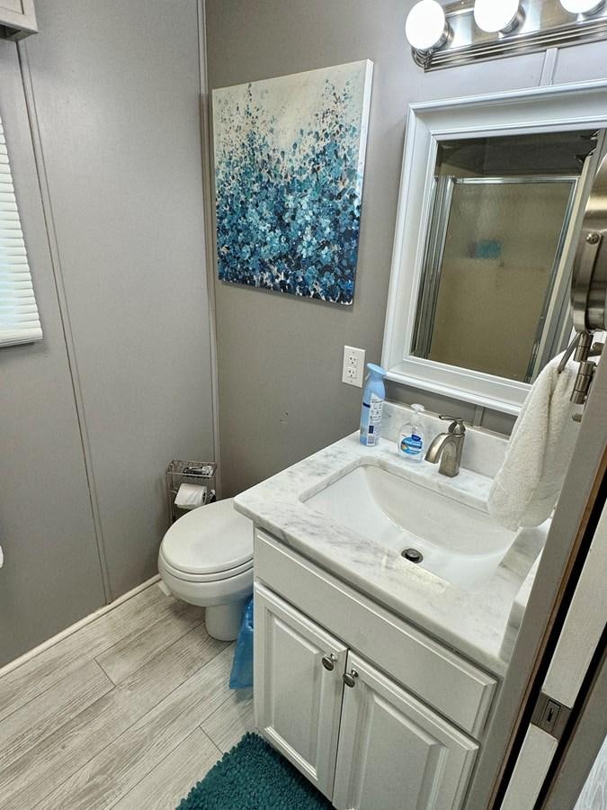 a bathroom with a sink and a toilet aboard 2012 MAJESTIC 16 X 75WB HOUSEBOAT NLSD Yacht for Sale
