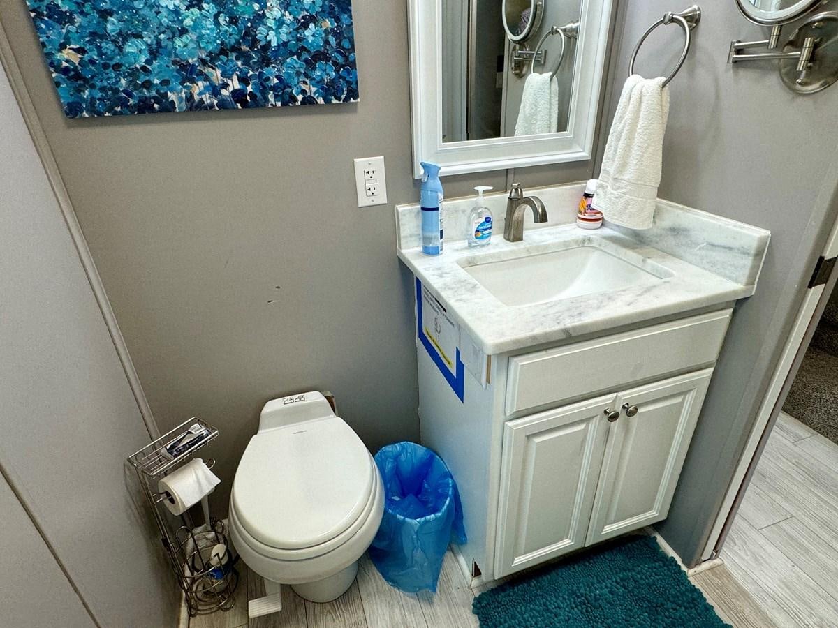 a bathroom with a sink toilet and a mirror aboard 2012 MAJESTIC 16 X 75WB HOUSEBOAT NLSD Yacht for Sale