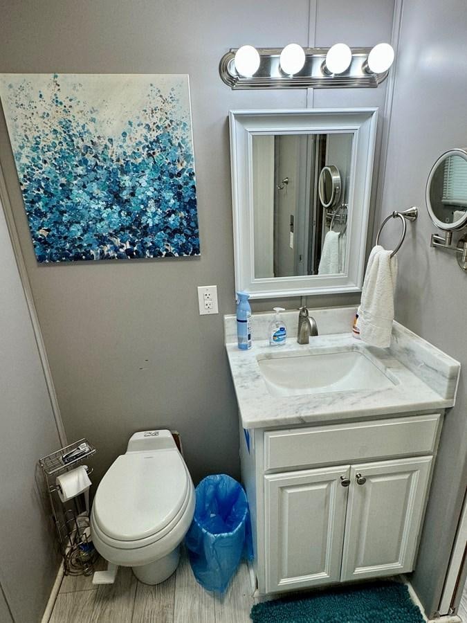 a bathroom with a sink toilet and mirror aboard 2012 MAJESTIC 16 X 75WB HOUSEBOAT NLSD Yacht for Sale