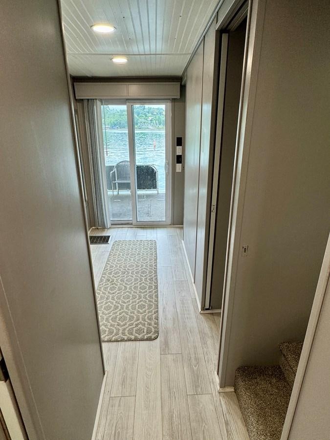 a hallway with a door and windows aboard 2012 MAJESTIC 16 X 75WB HOUSEBOAT NLSD Yacht for Sale