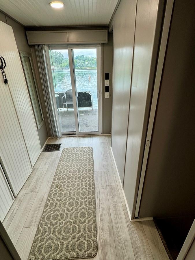 a hallway with a door and windows aboard 2012 MAJESTIC 16 X 75WB HOUSEBOAT NLSD Yacht for Sale