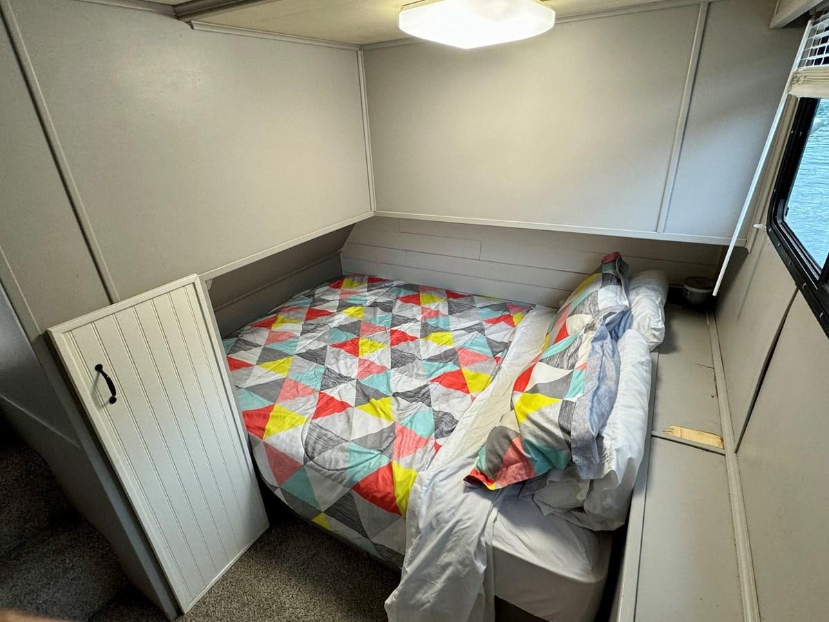 a bed in a room aboard 2012 MAJESTIC 16 X 75WB HOUSEBOAT NLSD Yacht for Sale