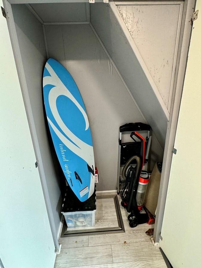 a blue surfboard leaning against a wall aboard 2012 MAJESTIC 16 X 75WB HOUSEBOAT NLSD Yacht for Sale
