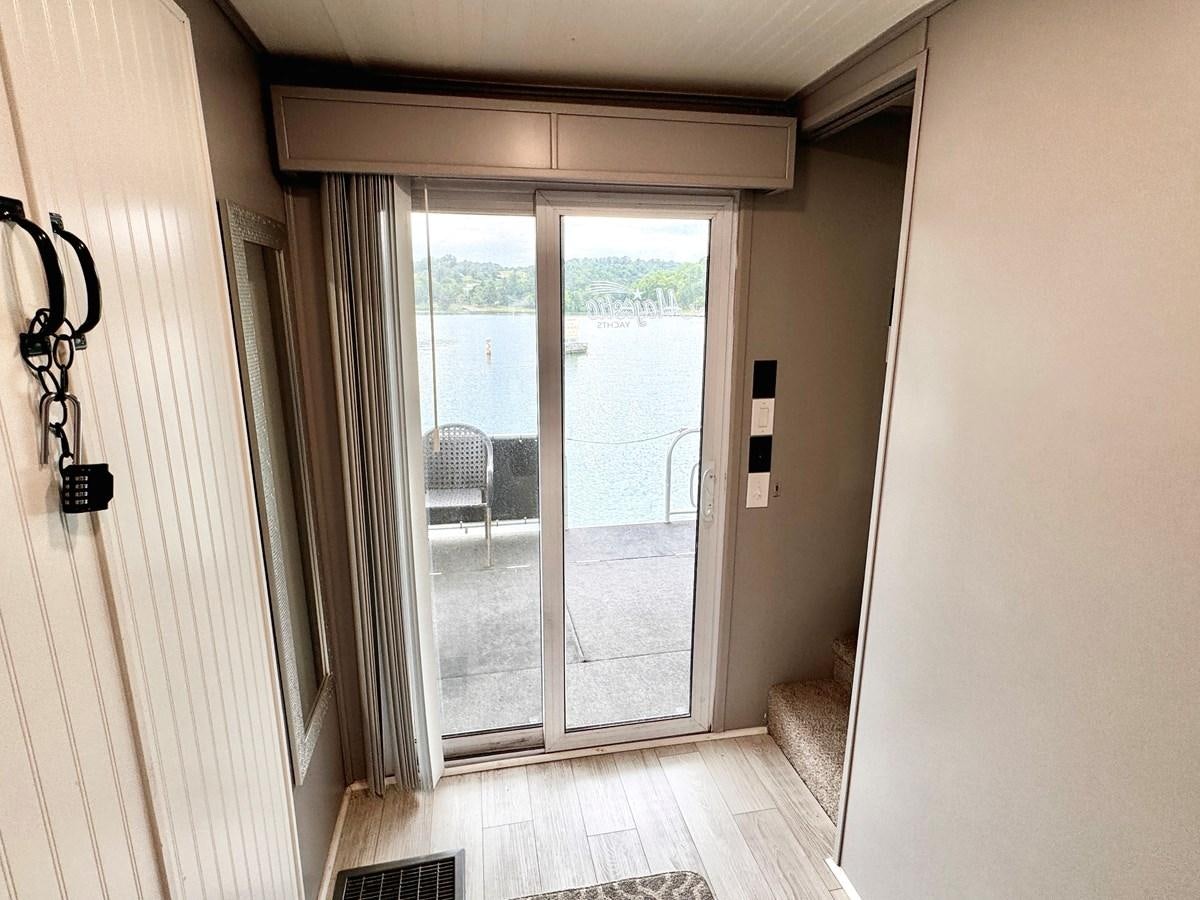 a room with a door and a glass door aboard 2012 MAJESTIC 16 X 75WB HOUSEBOAT NLSD Yacht for Sale