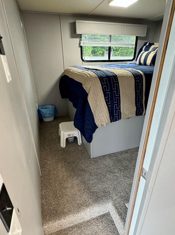 a bed with a blue sheet aboard 2012 MAJESTIC 16 X 75WB HOUSEBOAT NLSD Yacht for Sale