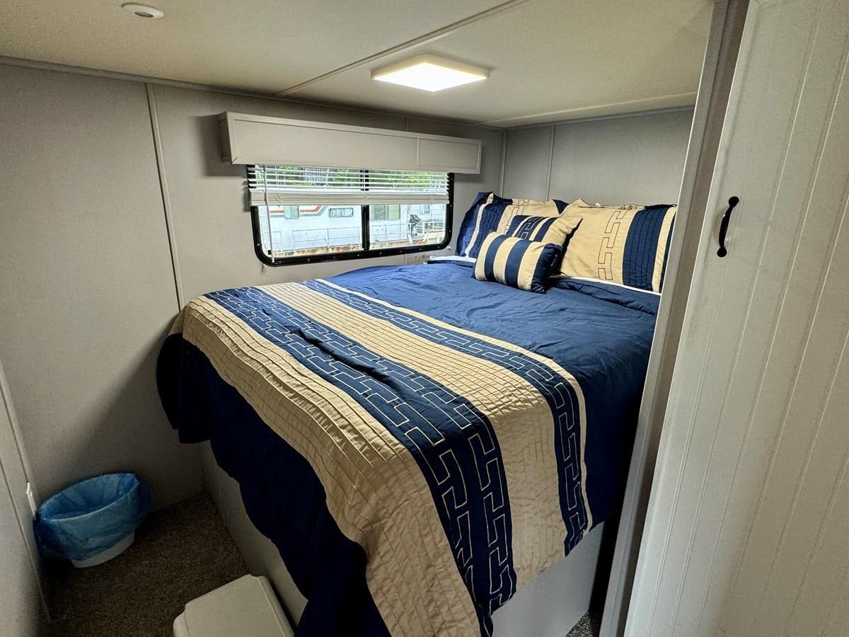 a bed in a room aboard 2012 MAJESTIC 16 X 75WB HOUSEBOAT NLSD Yacht for Sale