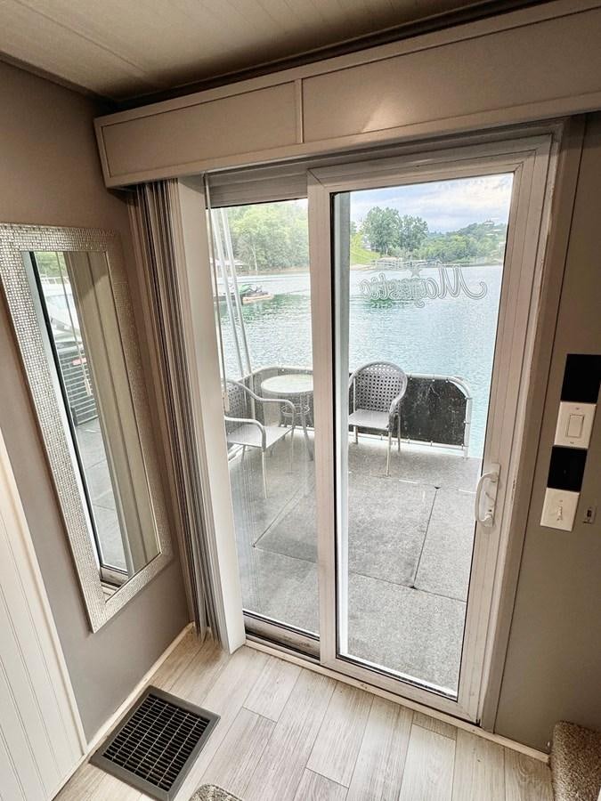 a room with a sliding glass door aboard 2012 MAJESTIC 16 X 75WB HOUSEBOAT NLSD Yacht for Sale