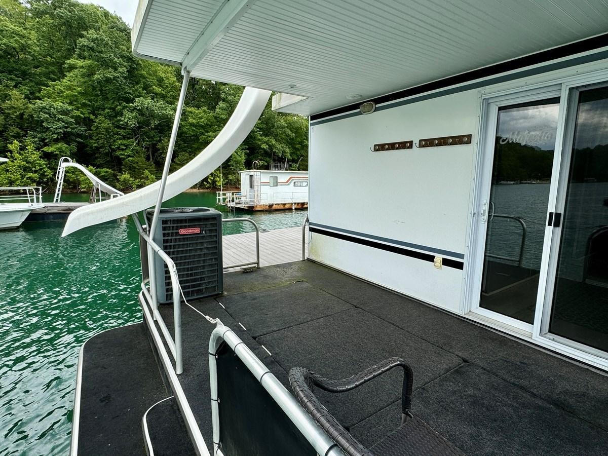 a boat on the water aboard 2012 MAJESTIC 16 X 75WB HOUSEBOAT NLSD Yacht for Sale