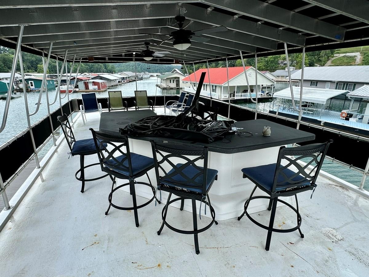 a table and chairs on a snowy area aboard 2012 MAJESTIC 16 X 75WB HOUSEBOAT NLSD Yacht for Sale