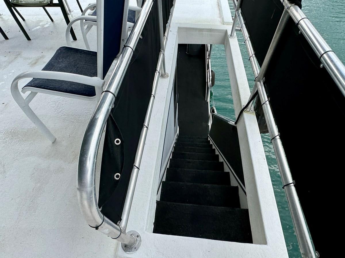 a black and white staircase aboard 2012 MAJESTIC 16 X 75WB HOUSEBOAT NLSD Yacht for Sale