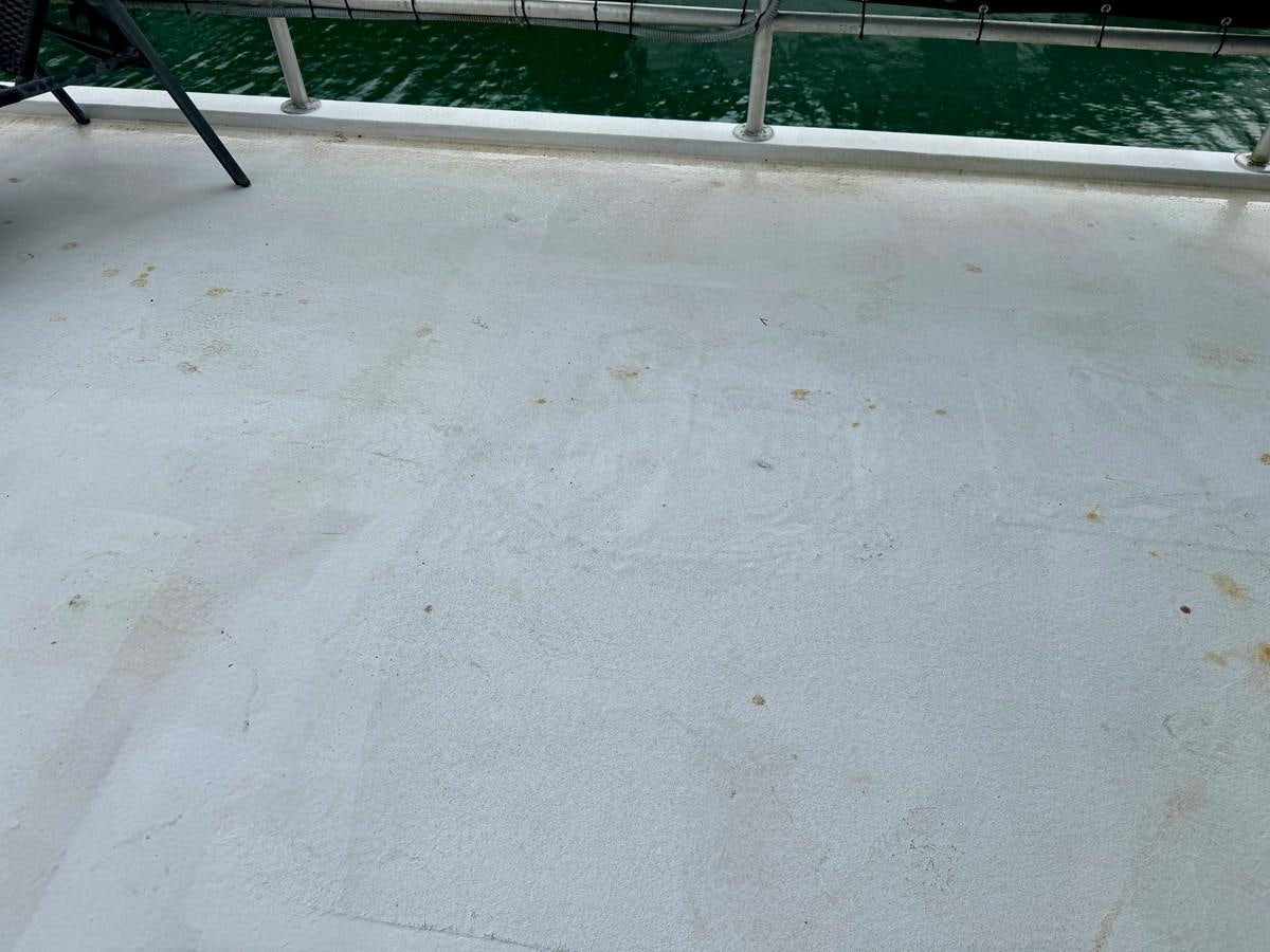 a white surface with a fence and a green fence aboard 2012 MAJESTIC 16 X 75WB HOUSEBOAT NLSD Yacht for Sale