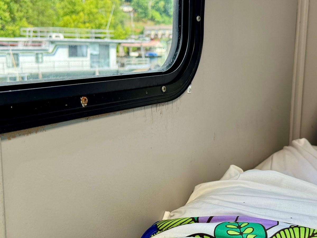 a window with a view of a city and trees aboard 2012 MAJESTIC 16 X 75WB HOUSEBOAT NLSD Yacht for Sale