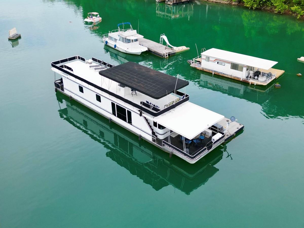 a boat on the water aboard 2012 MAJESTIC 16 X 75WB HOUSEBOAT NLSD Yacht for Sale