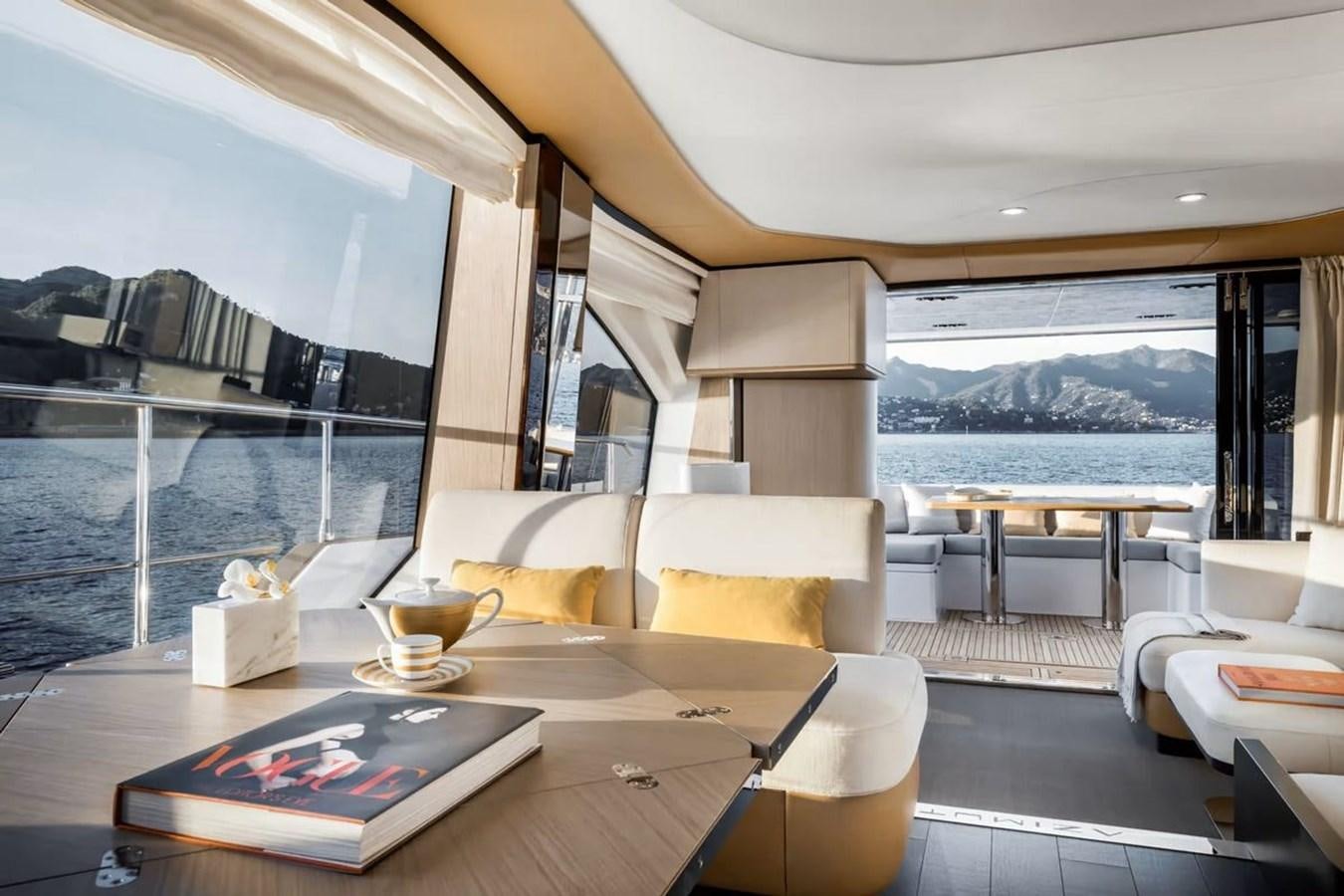 a room with a table chairs and a view of the water aboard 2023 AZIMUT FLY 78/56 Yacht for Sale