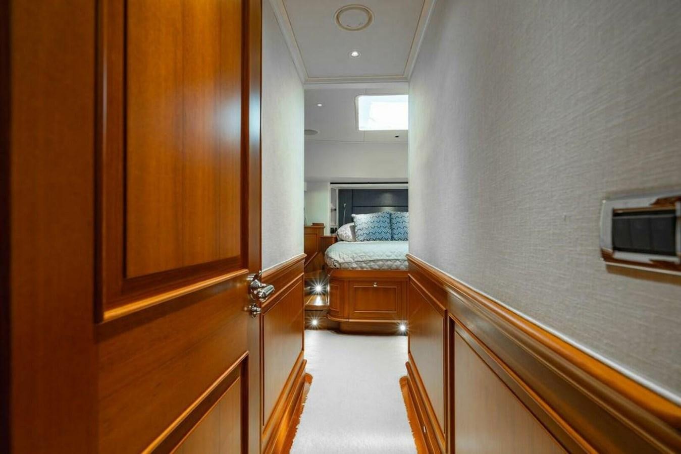 a hallway with a bed and a wood door aboard PHOEBE Yacht for Sale