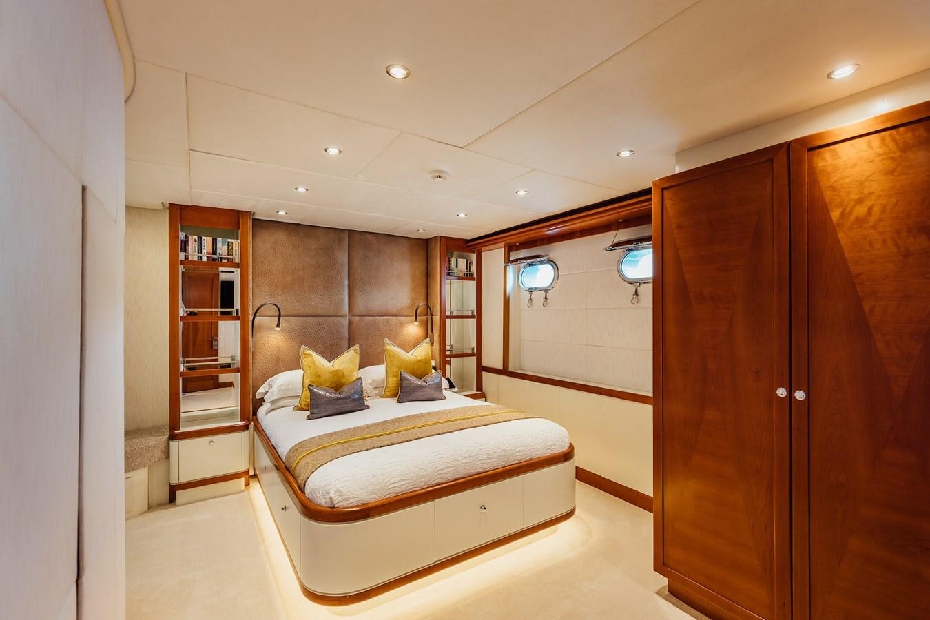 a bedroom with a bed and a bookcase aboard ZULU Yacht for Sale